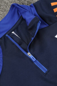 Close-up of a navy jacket with a blue zipper, partially unzipped to reveal the inner lining.