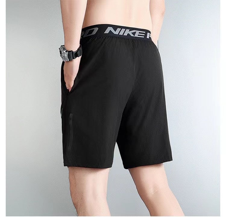 d4c247b7 | UAE SPORT STORE Back view of a person wearing black Nike athletic shorts with an elastic waistband and hand in pocket, gym/athletic style.