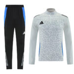 Matching training set: black pants with blue side panels, and a light gray leopard-print long-sleeve top with a zip and Adidas logo.