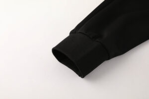 d56dac5c_5ea53432-c74f-4211-8cd9-141b0eb00e5f | UAE SPORT STORE Close-up of a black jacket sleeve cuff with ribbed knit detail on a white background.