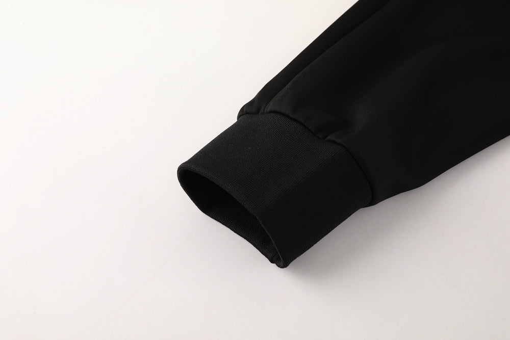 d56dac5c_5ea53432-c74f-4211-8cd9-141b0eb00e5f | UAE SPORT STORE Close-up of a black jacket sleeve cuff with ribbed knit detail on a white background.