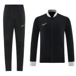 Black Nike tracksuit set: full-zip jacket with grey cuffs and collar, paired with black jogger pants showing a white Nike swoosh.