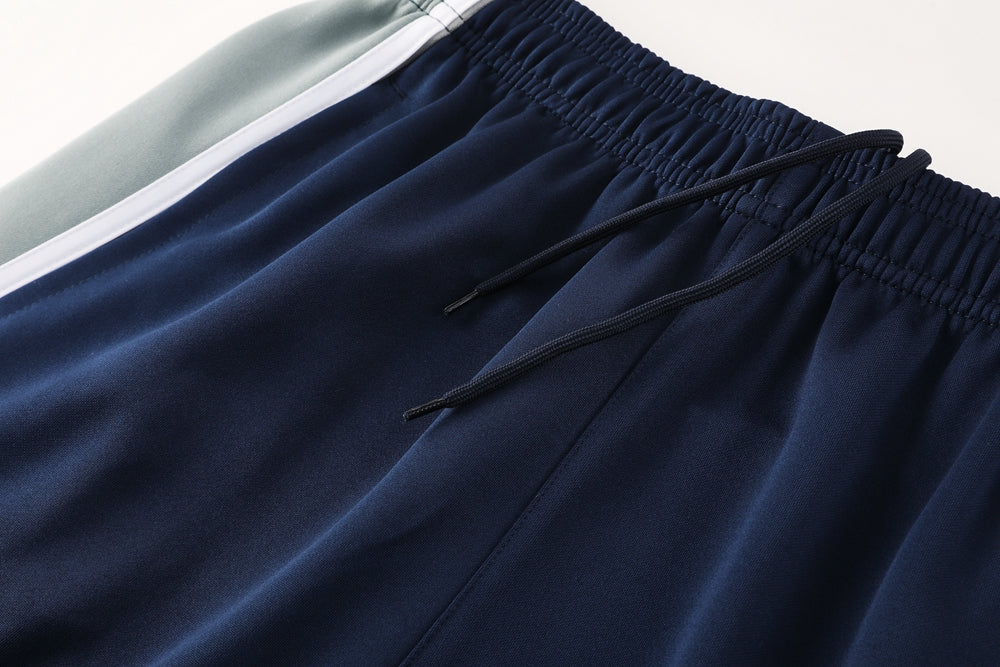 d6545af2 | UAE SPORT STORE Close-up of navy athletic shorts waistband with a drawstring and a light blue stripe nearby.