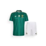 Green soccer jersey with gold trim and crest, paired with white shorts. It appears to be a South African national team kit.
