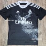 Black Real Madrid soccer jersey with white Adidas stripes, crest, and Fly Emirates sponsor featuring a white dragon graphic across the front.