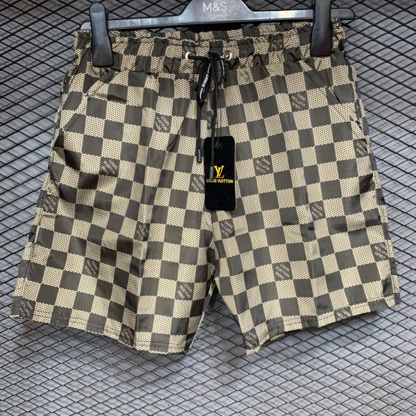 d7807d5b-fac5-42ee-bb44-825dfc0bdf75 | UAE SPORT STORE Patterned Louis Vuitton swim shorts on a hanger with a black LV tag visible.