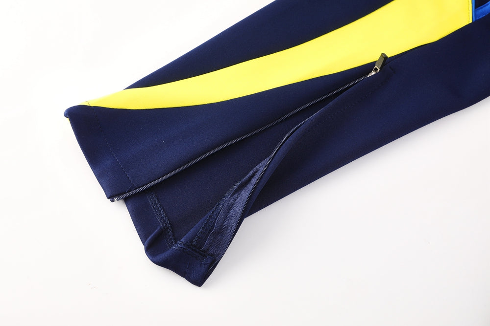 d8617964 | UAE SPORT STORE Zippered navy blue fabric with a bright yellow stripe along the edge, likely a clothing sleeve or leg with zipper partially open