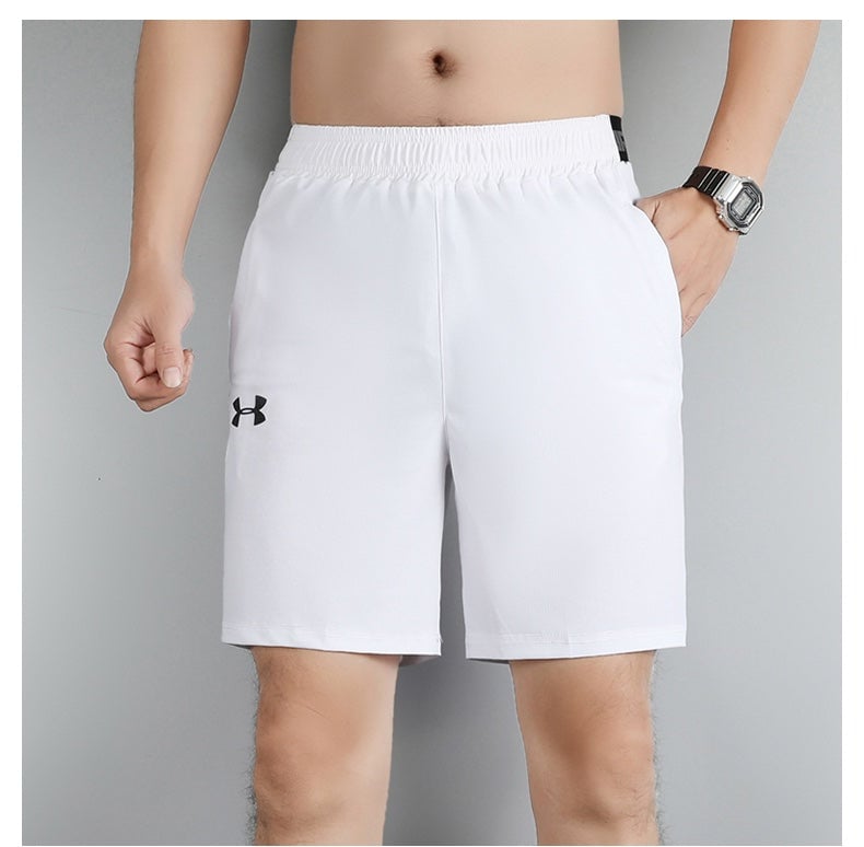 d8d21745 | UAE SPORT STORE White athletic shorts with a black Under Armour logo on the left leg, elastic waistband, shown on a male model with a watch.