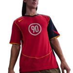 Person wearing a red soccer jersey with the number 90 in a white circle on the chest, with yellow trim.