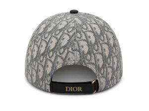 Back view of a grey textured cap with a black strap and gold buckle featuring the Dior logo