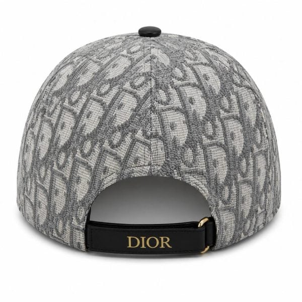 Back view of a grey textured cap with a black strap and gold buckle featuring the Dior logo