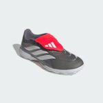 Grey running shoe with a bright red strap over the laces and white side stripes on a light background.