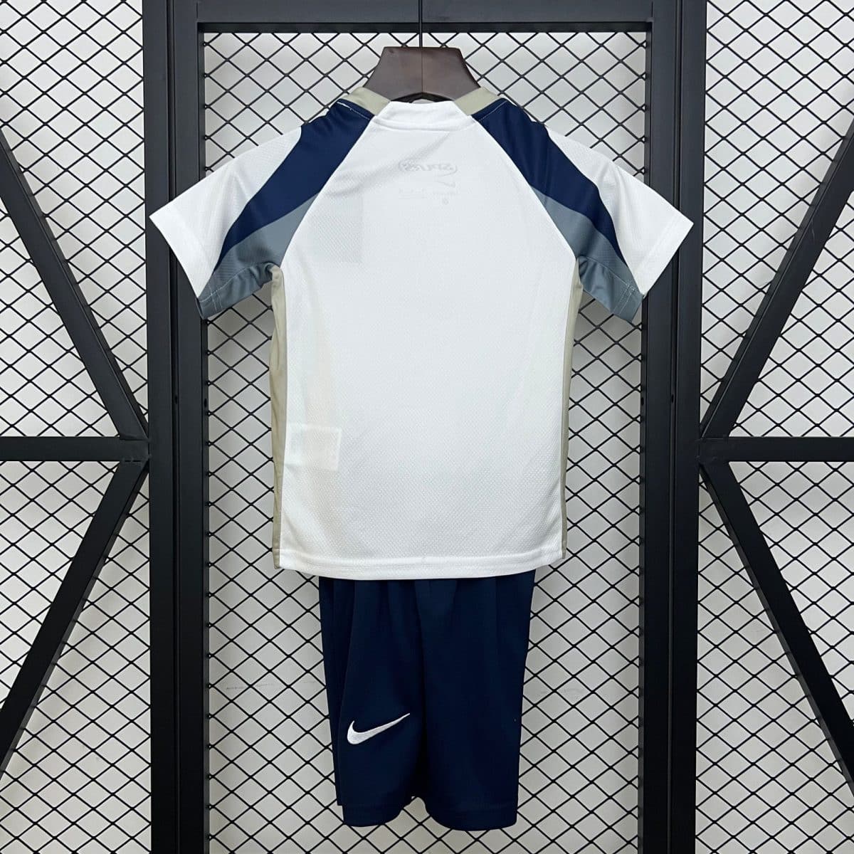 White athletic jersey hanging on a wooden hanger, with dark blue sleeves and light gray accents, displayed against a metal mesh locker backdrop.