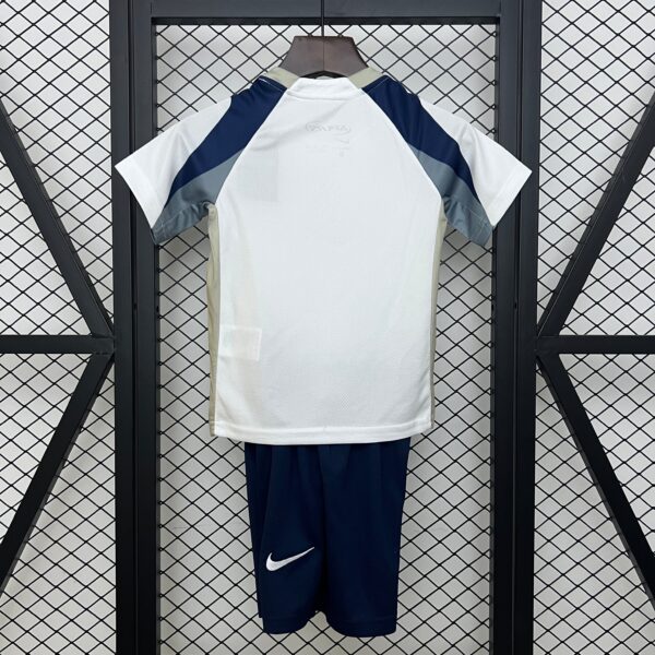 White athletic jersey hanging on a wooden hanger, with dark blue sleeves and light gray accents, displayed against a metal mesh locker backdrop.