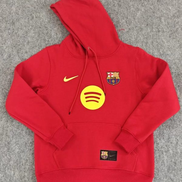 Red Barcelona hooded sweatshirt with a yellow Nike swoosh and Spotify logo on the front, display on a gray surface.