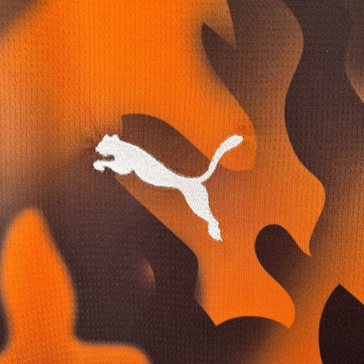 Close-up of orange and brown camouflage fabric texture.