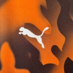 db60e860_c073345a-5a62-42e4-9d8a-6c722b13626f | UAE SPORT STORE Close-up of orange and brown camouflage fabric texture.