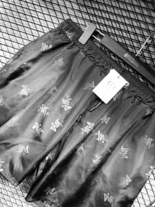 Dior-logoed puffer pants with a white tag resting in a shopping cart basket.