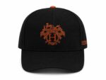 Heritage Crest luxury cap with embroidered crest and orange accents.