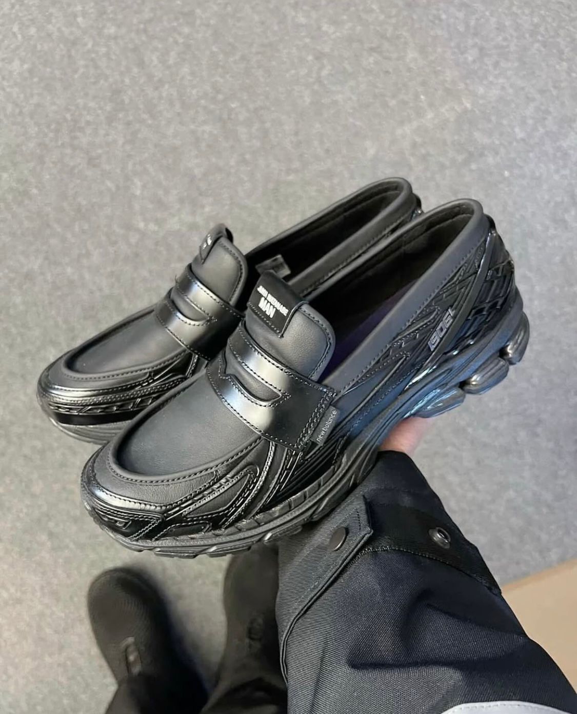 dc16f010-be88-41c7-aa36-529a6f5c8ece | UAE SPORT STORE Black chunky athletic sneakers with two Velcro straps and a thick, textured sole.