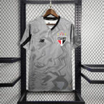 Gray camouflage-pattern SPFC football jersey on a wooden hanger in a display rack.