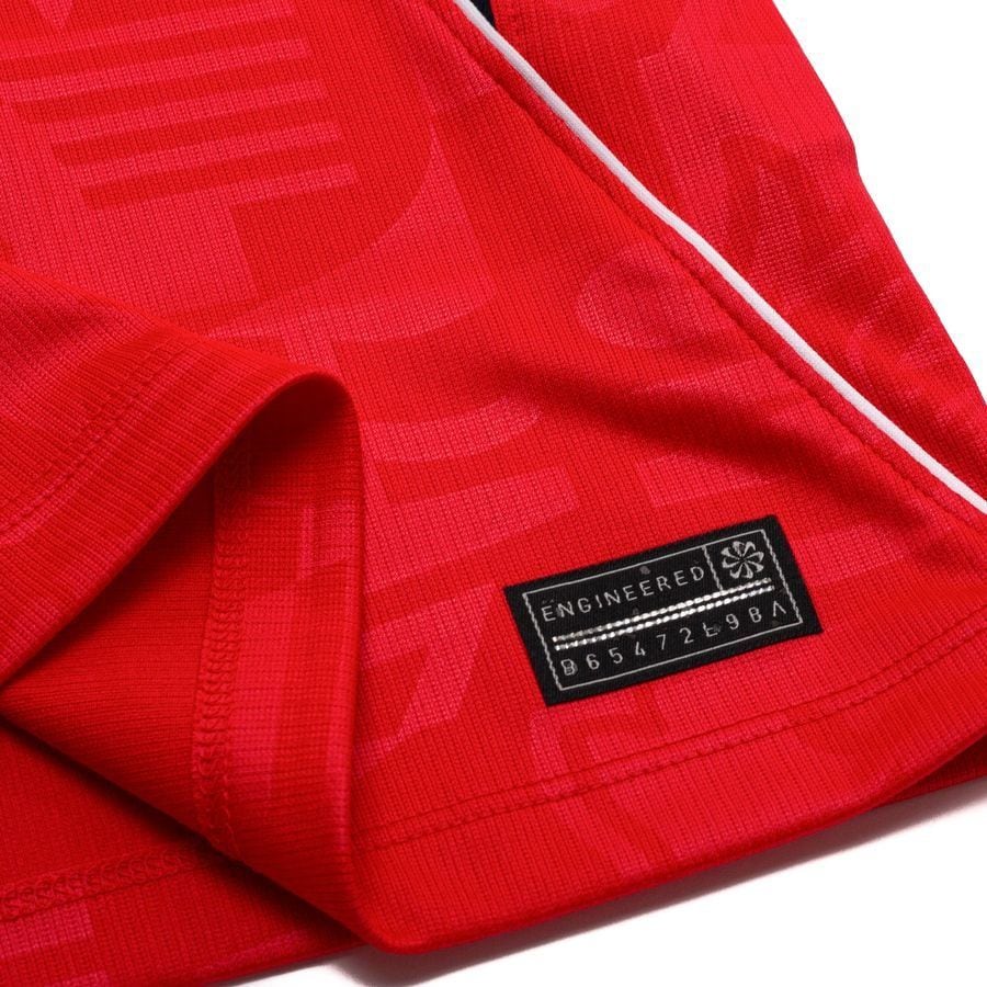 dd1677d85c04 | UAE SPORT STORE Close-up of red fabric with a black label reading 'ENGINEERED' and serial-like numbers
