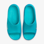 Top-down view of a pair of turquoise slide sandals with a small Nike swoosh on each strap.