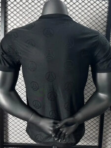 Back view of a black T-shirt on a mannequin with a subtle repeating logo pattern across the fabric.