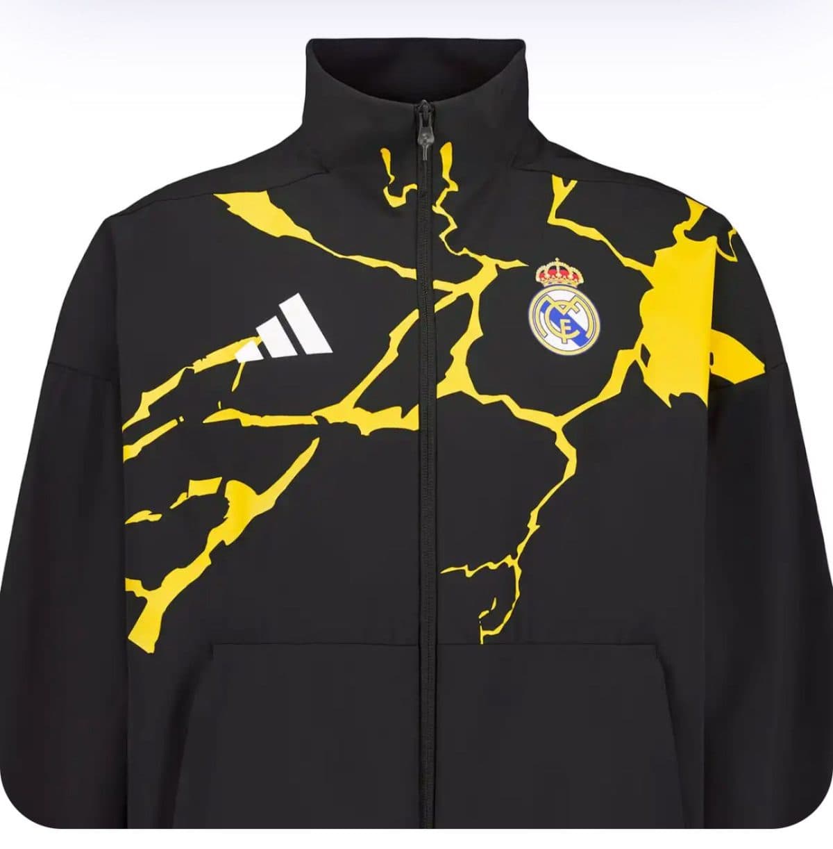 Black Real Madrid windbreaker-style jacket with a bold yellow crackle pattern and Real Madrid crest on the chest, full-zip front.