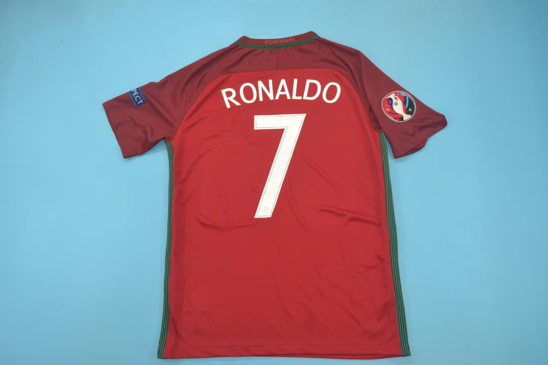 dfhfh_e06769fd-8fbe-40c3-9b47-2841bc1d62f9 | UAE SPORT STORE Red Portugal soccer jersey with Ronaldo name and number 7 laid flat on a blue background