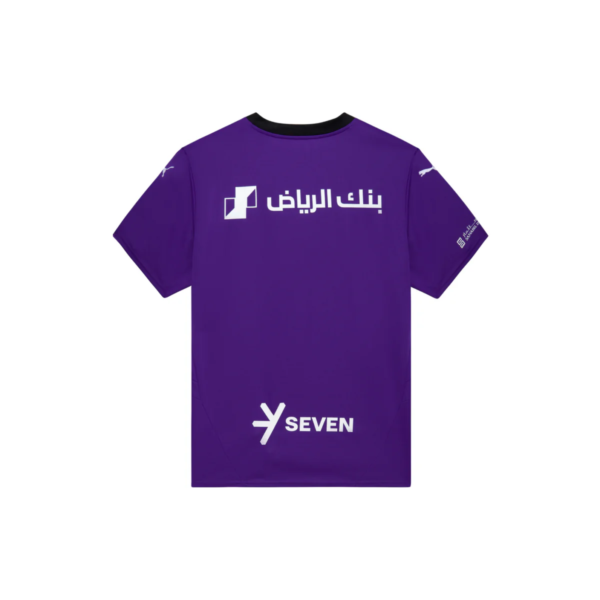 Back view of a purple sports jersey with white logos: Arabic text across the upper back and a 'SEVEN' logo toward the lower back.