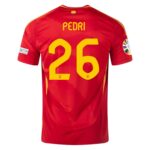 Back view of a red Spain national team jersey with the name PEDRI in yellow and a large yellow 26 on the back, plus sleeve patches.