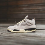 Beige athletic sneaker with cream sole on a wooden surface, side view.