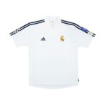 dsfsdfffdf_62e18cc7-8e89-40a1-bce3-f2fa89dc8ada | UAE SPORT STORE White Real Madrid football jersey with navy stripes, Adidas logo, Real Madrid crest, and Champions League badge on the sleeve.