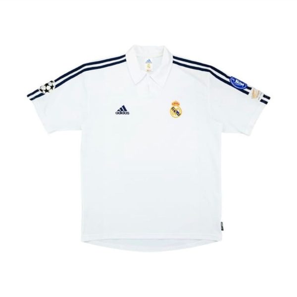 White Real Madrid football jersey with navy stripes, Adidas logo, Real Madrid crest, and Champions League badge on the sleeve.