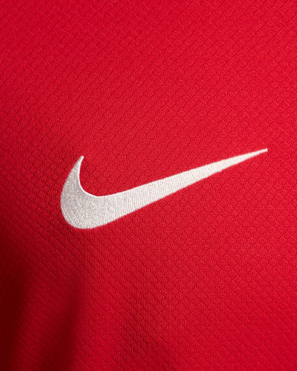 White Nike swoosh logo on red athletic fabric (close-up)