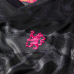 e11faa3c_5dd9_47d8_891d_b0d5b8fc3307 | UAE SPORT STORE Close-up of a black sports jersey with a pink embroidered lion crest.