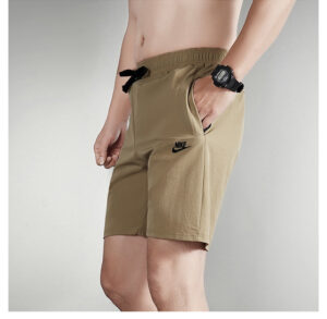 e126f16f | UAE SPORT STORE Beige Nike athletic shorts with a black drawstring and side pocket on a model