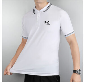 Man modeling a white Under Armour polo shirt with a small logo on the chest, striped collar and sleeve cuffs.