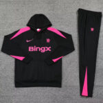 Black athletic hoodie with pink panels and BingX logo, paired with matching black jogger pants with pink accent stripe, laid flat on a gray surface.