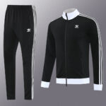 Black Adidas tracksuit set: zip-up jacket with white collar and cuffs, matching black pants with white side stripes and logo.