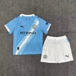 Manchester City football kit laid flat: light blue jersey with diagonal white stripes, club crest, and Etihad Airways sponsor, paired with white shorts and Puma logos.