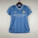 Blue Manchester City football jersey on a hanger, featuring the club crest and Etihad Airways sponsor text.