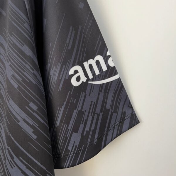 Close-up of dark gray fabric with a diagonal line pattern and partial white lettering along the edge.
