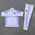 e52ec510 | UAE SPORT STORE Lavender Nike Air tracksuit (jacket and pants) laid flat with lavender and lilac color blocks and a small black Nike Air logo on the chest.