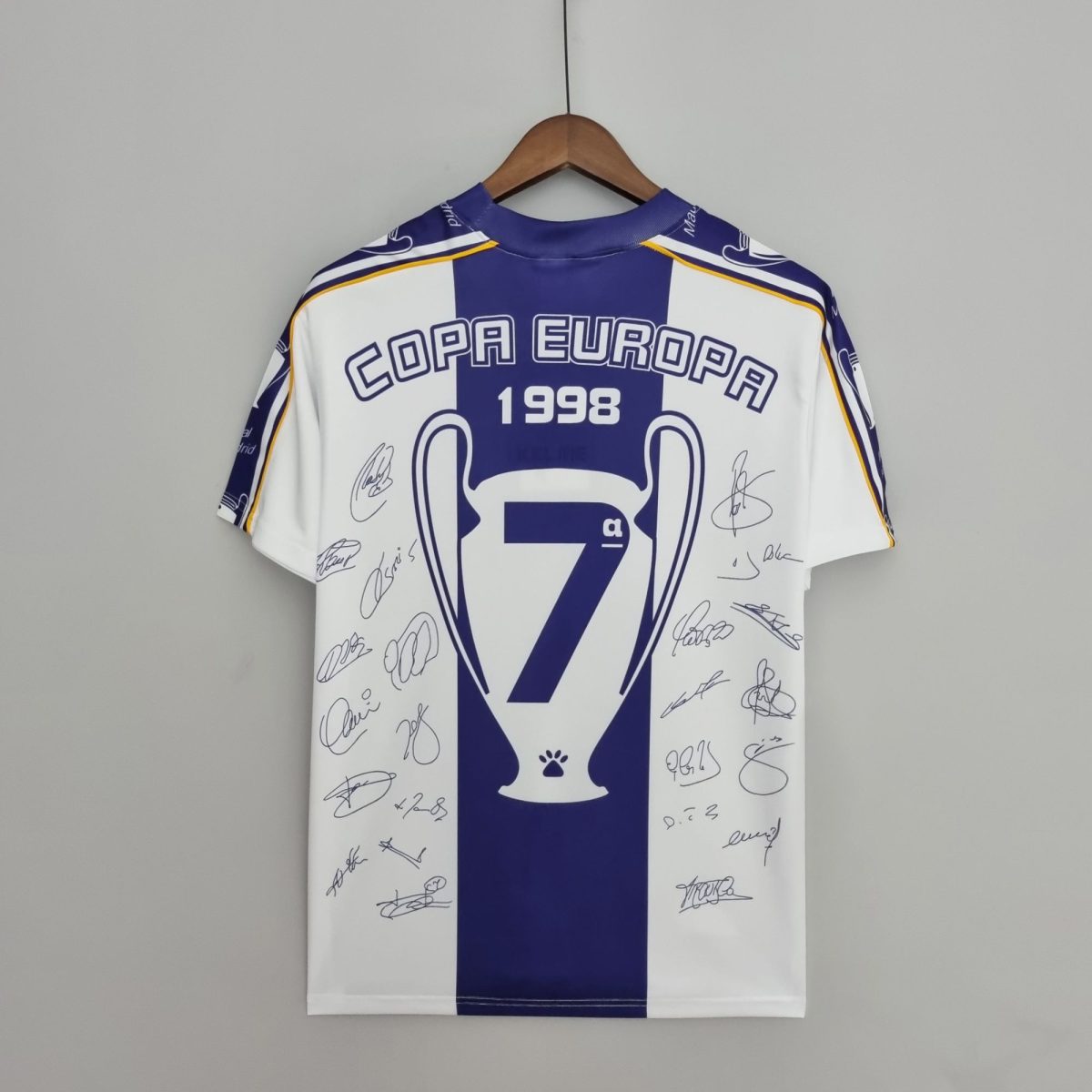 Autographed blue-and-white football jersey on a wooden hanger, displaying 'COPA EUROPA 1998' text and signatures.