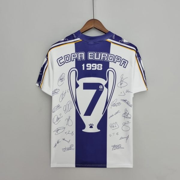 Autographed blue-and-white football jersey on a wooden hanger, displaying 'COPA EUROPA 1998' text and signatures.