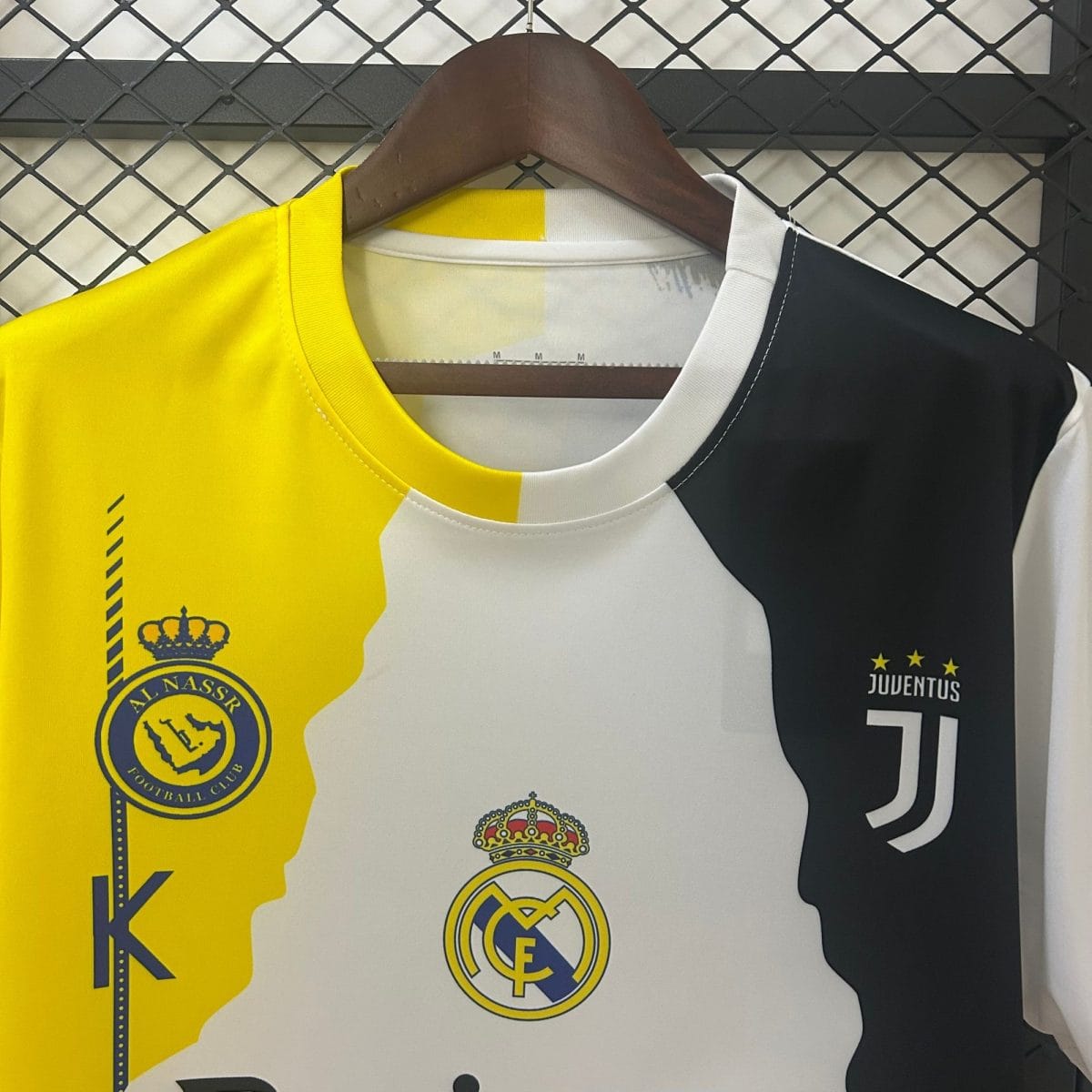 Close-up of hanging football jerseys showing club crests (Al Nassr, Real Madrid, and Juventus) on yellow, white, and dark fabrics.