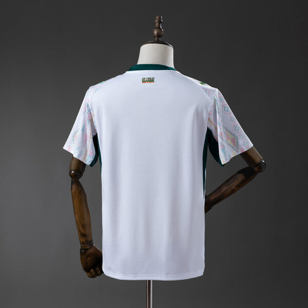 White short-sleeve jersey displayed from the back on a mannequin, with patterned sleeves and a small logo at the neck.