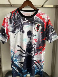 Graphic T-shirt on a hanger with a Japan JFA crest and a stylized black-and-white samurai amid red, blue, and gray abstract art.